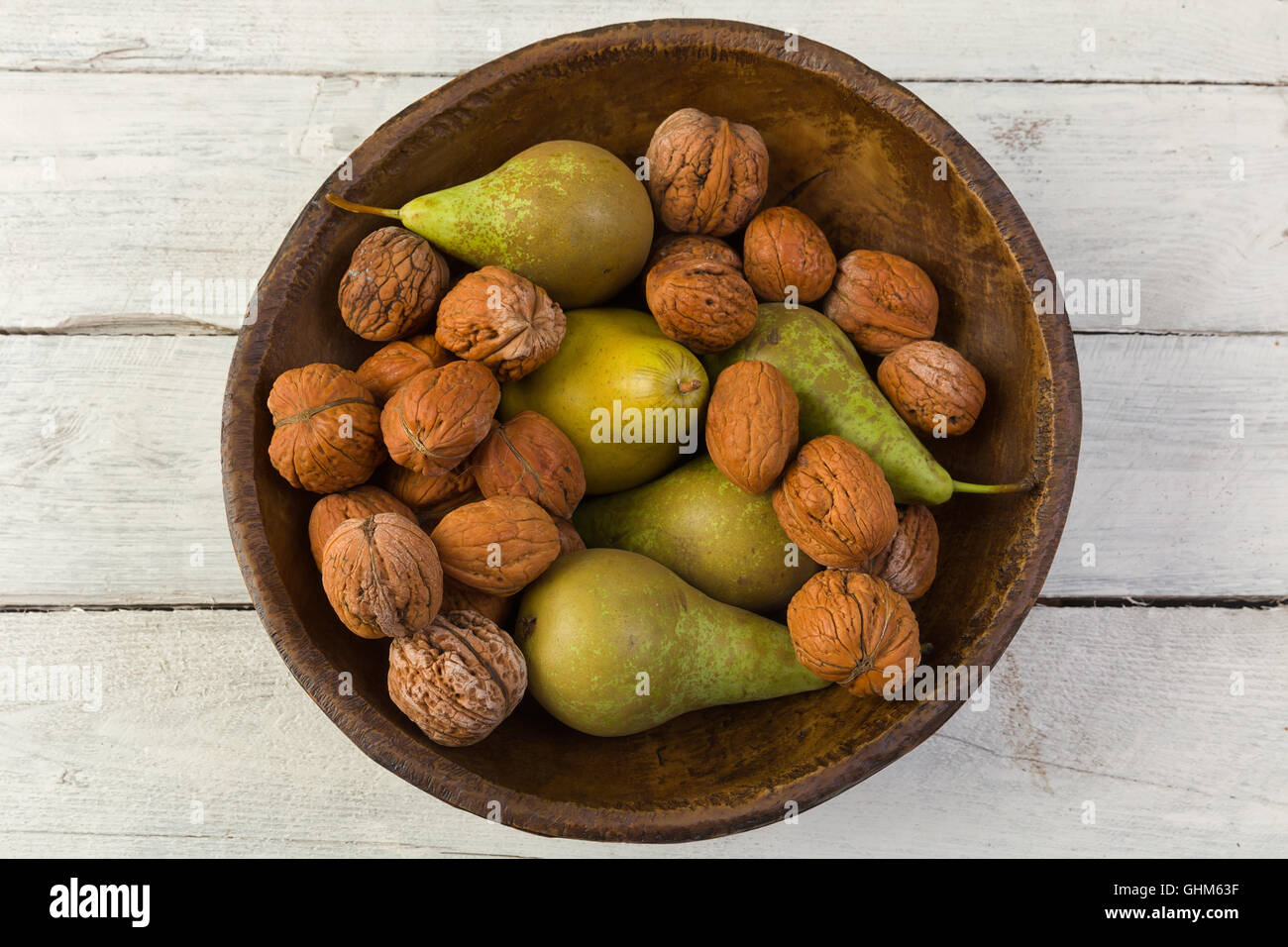 Rientrano ancora in vita con una ciotola di pere e noci su un grunge sfondo di legno Foto Stock