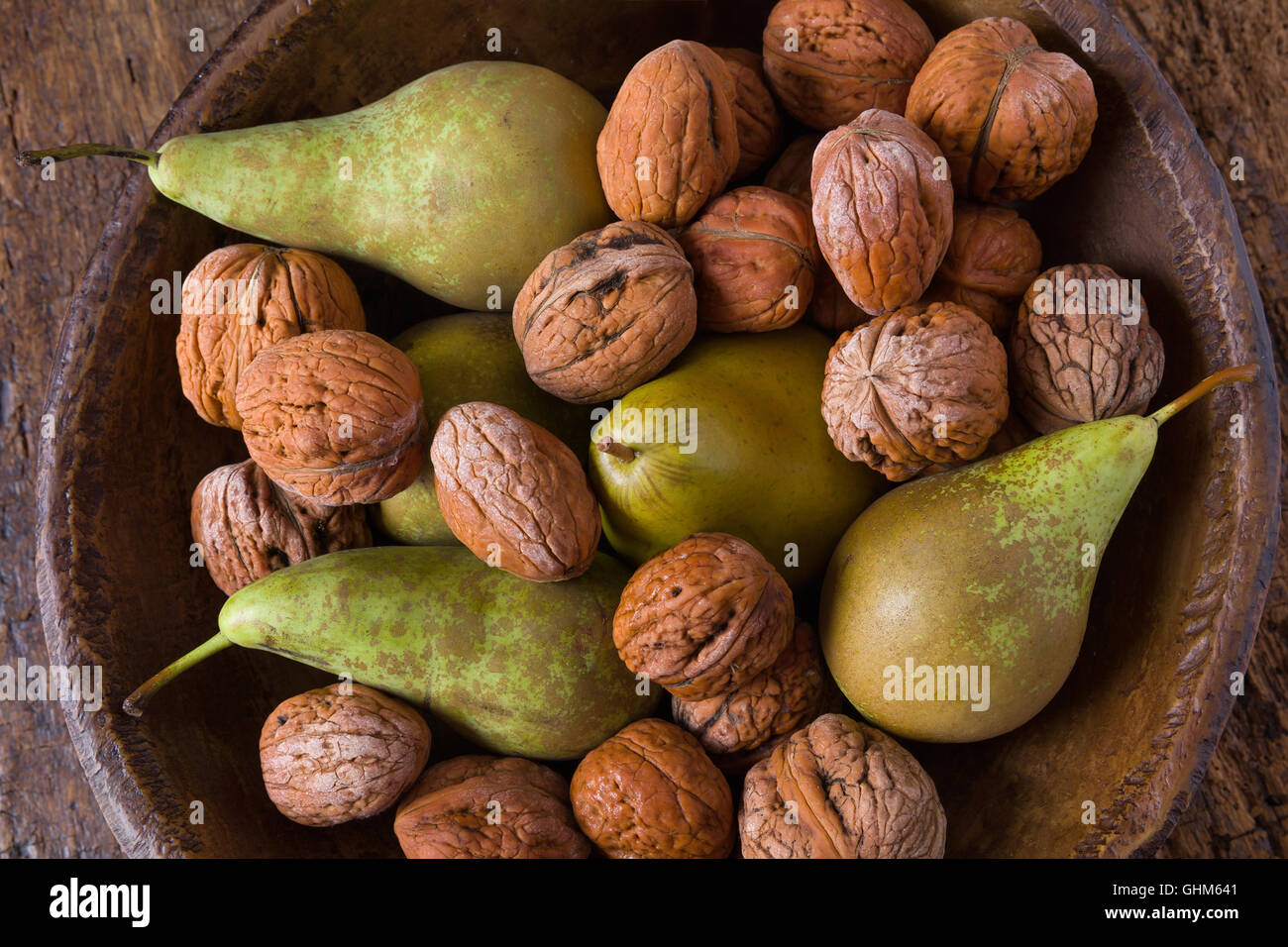 Autunno still life di caduta foglie e noci su un grunge sfondo di legno Foto Stock