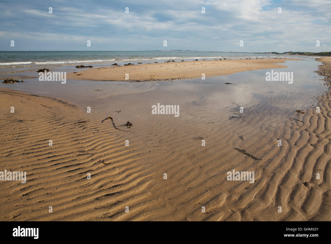 Modelli di onde sulla spiaggia di Druridge Bay in Northumberland, Inghilterra. Il mare del Nord giri sulla battigia. Foto Stock