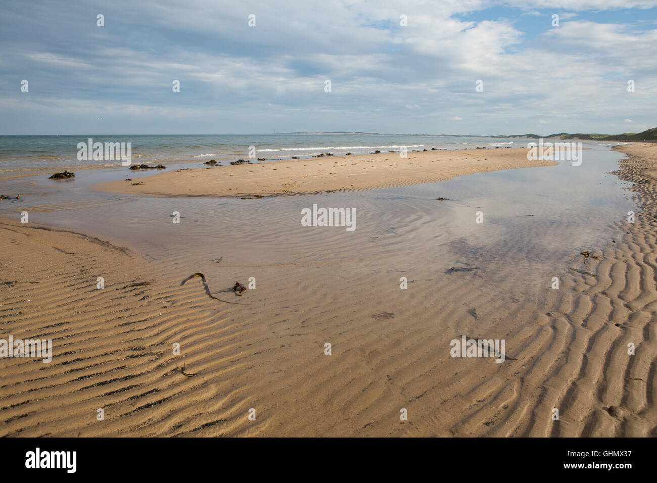 Modelli di onde sulla spiaggia di Druridge Bay in Northumberland, Inghilterra. Il mare del Nord giri sulla battigia. Foto Stock