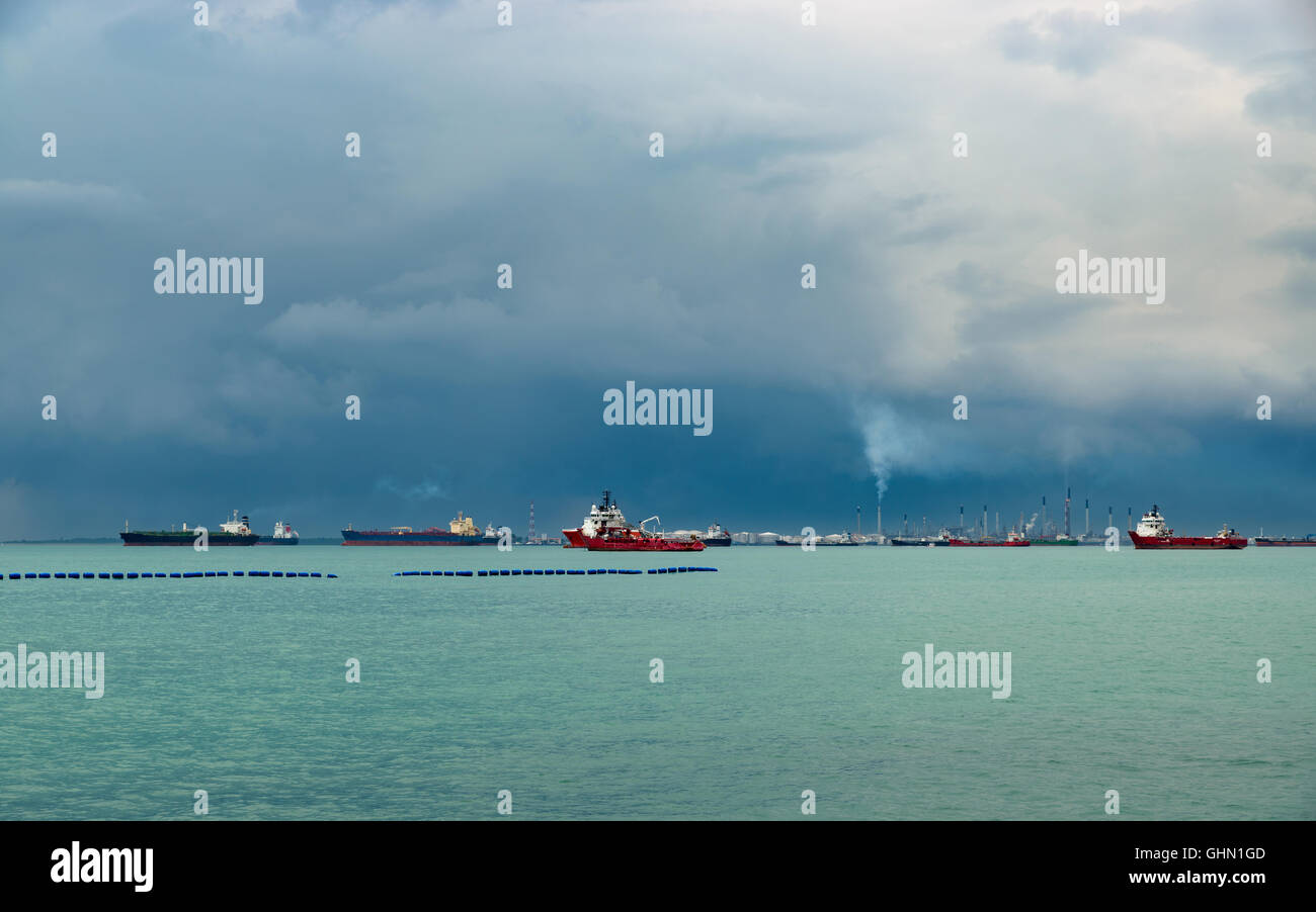 Vista del Singapore stretto da l'Isola di Sentosa. Navi, paesaggio industriale e le tempeste. Foto Stock