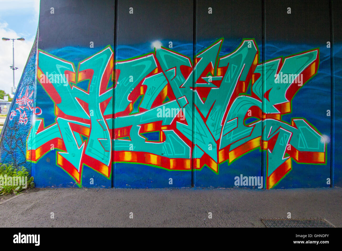 Vivace stile selvaggio pezzo di graffiti spruzzato sul calcestruzzo sottopassaggio Foto Stock