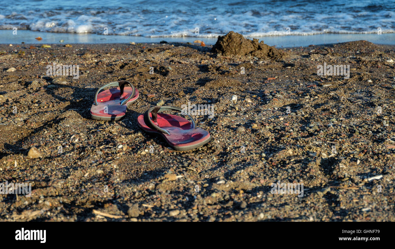 Una coppia di sandalo rosso su una spiaggia Foto Stock