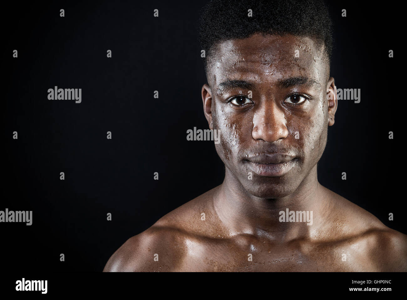 Atleta atleta colpo di testa sudorazione faccia umido dopo esercizio intenso ritratto guardare da vicino il nero isolato Foto Stock