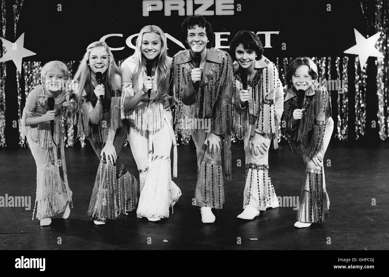 Die Famiglia Brady - Mit ihren sechs Kindern wohnen Carol und Mike Brady glücklich und zufrieden in einem Vorort von Los Angeles. Ihre Träume waren die 70er Jahre - und den Lebensstil von damals pflegen sie heute noch. Doch ihre Idylle gerät in Gefahr, als sie 20.000 dollari nachzahlen Steuern sollen - eine Summe, die sie niemals aufbringen können. Greg scheint eine Möglichkeit zu sehen, das Drama abzuwenden. Der bevorstehende Musik-Wettbewerb kommt da gerade recht. Immerhin beträgt der erste Preis genau 20.000 dollari. Szene mit den BRADY-KINDERN Regie: Betty Thomas aka. La Brady Bunch Movie Foto Stock