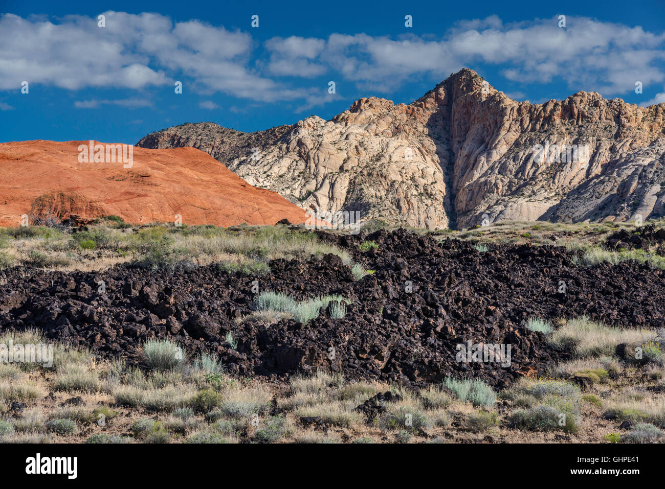 Rocce laviche, bianco e rosso di arenaria Navajo formazioni rocciose, Flusso di Lava Trail a Snow Canyon State Park, Utah, Stati Uniti d'America Foto Stock