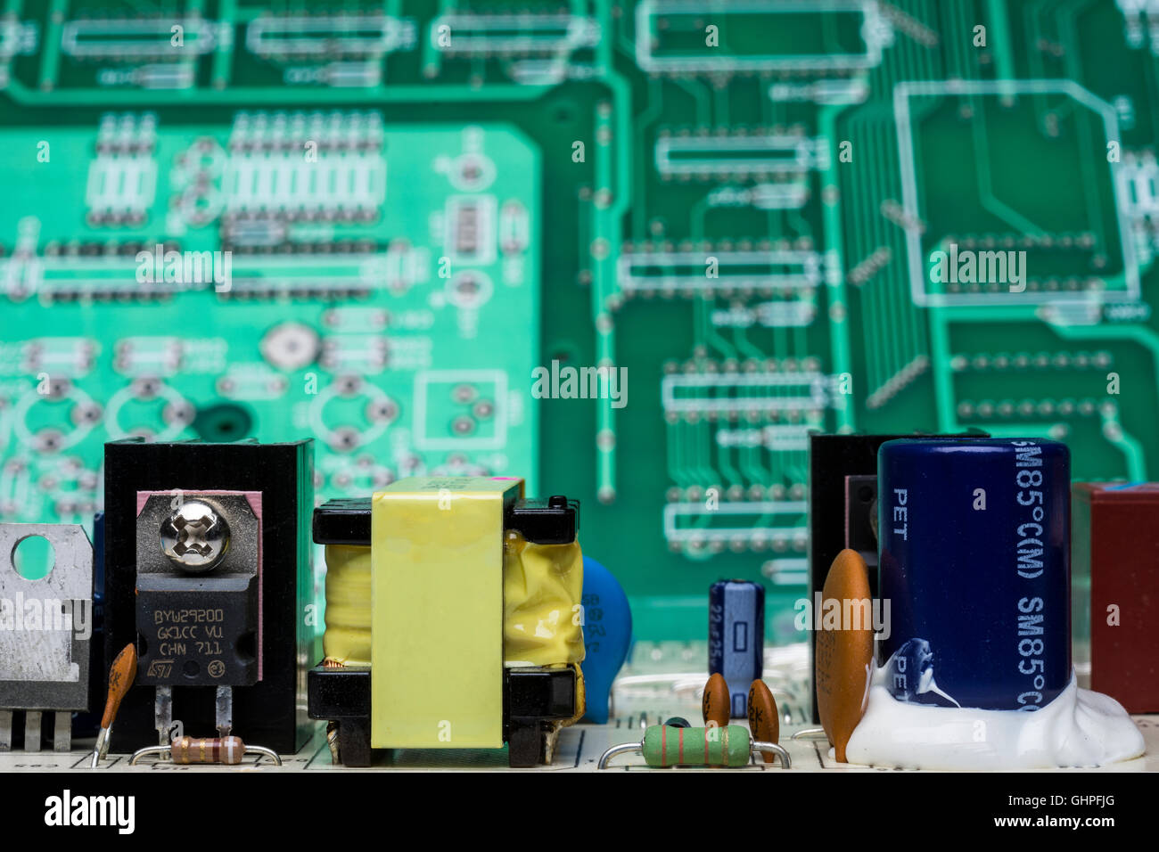Un focus scheda a circuito stampato con componenti ha un due-tono verde circuito stampato dietro di esso che è fuori della profondità di campo. Foto Stock