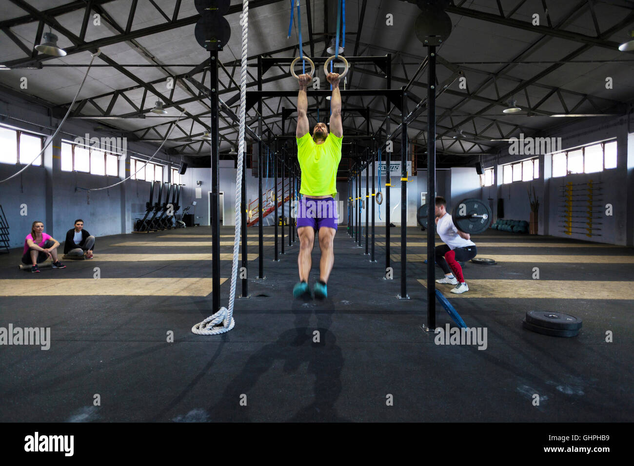 L'uomo facendo palestra esercizio sugli anelli in palestra Foto Stock