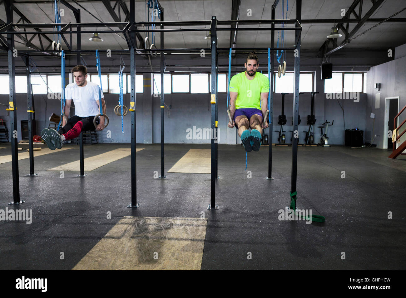 Due uomini facendo palestra esercizio sugli anelli in palestra Foto Stock