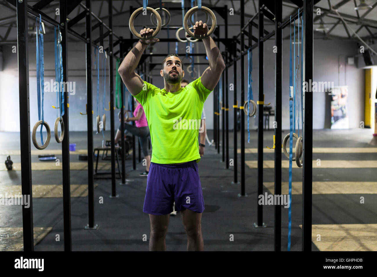 L'uomo facendo palestra esercizio sugli anelli in palestra Foto Stock