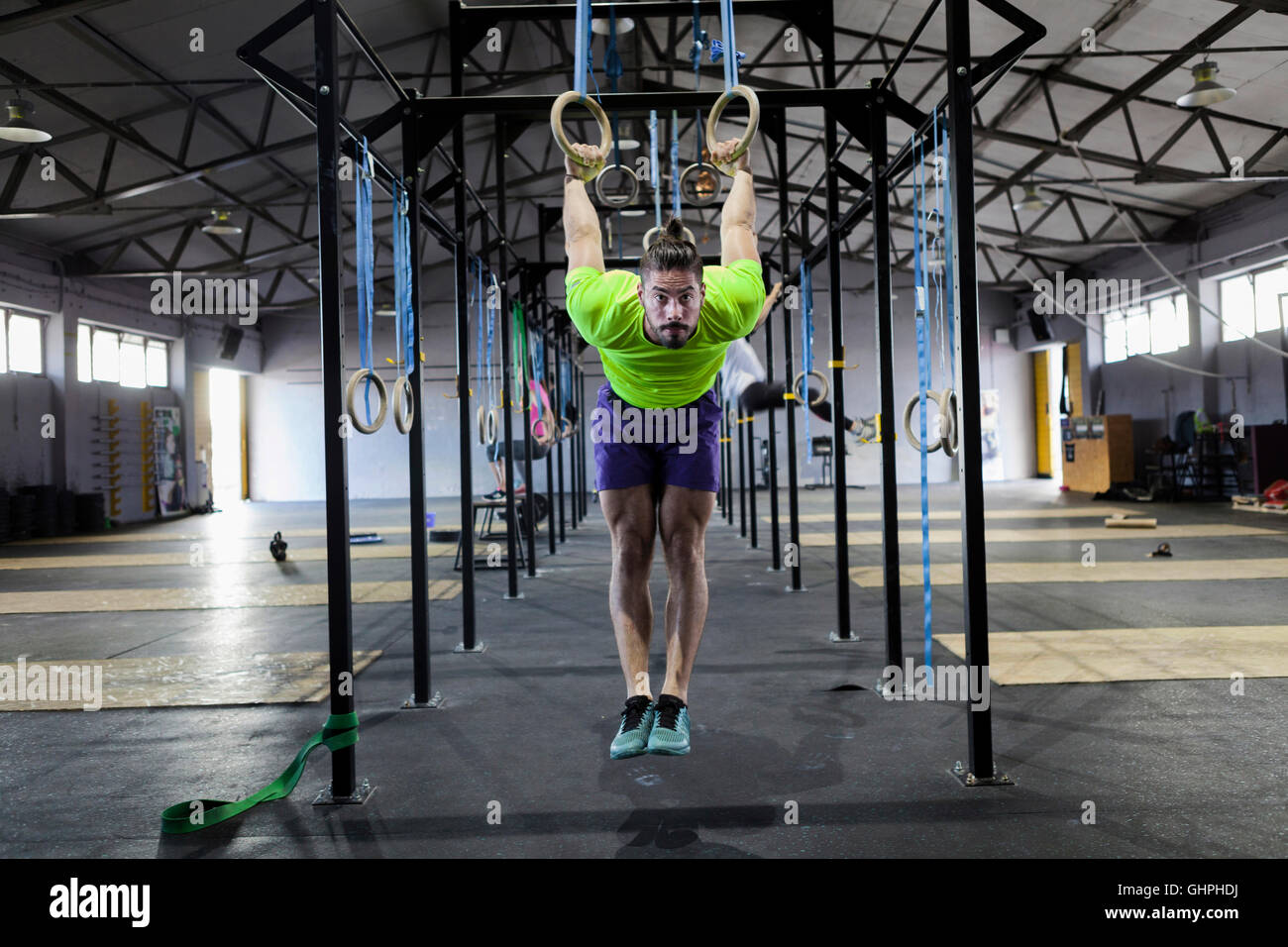 L'uomo facendo palestra esercizio sugli anelli in palestra Foto Stock