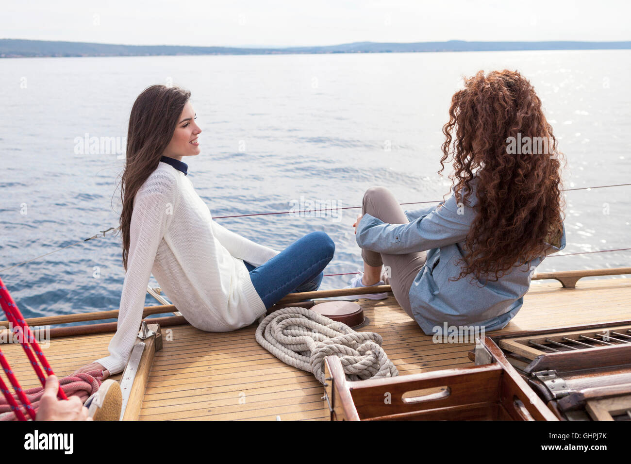 Due donne piedi sospesi al di sopra del bordo della barca Foto Stock