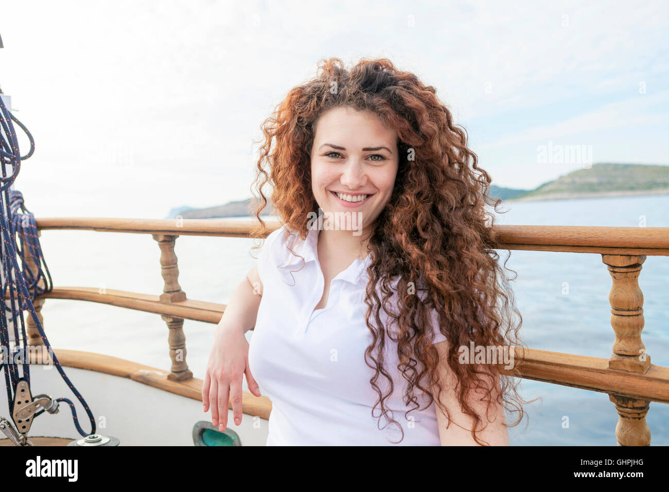 Ritratto di bella donna con capelli ricci sulla barca a vela Foto Stock