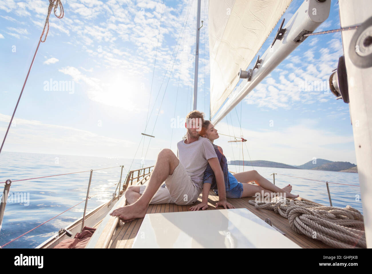 Coppia giovane seduta di schiena su barche a vela Foto Stock