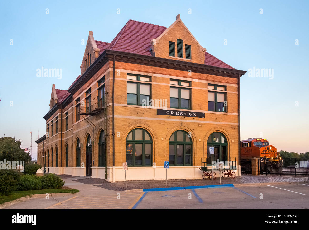 CB&Q Railroad Depot, Creston, IA. Attualmente Creston City Hall. Con BNSF treno passa. Foto Stock