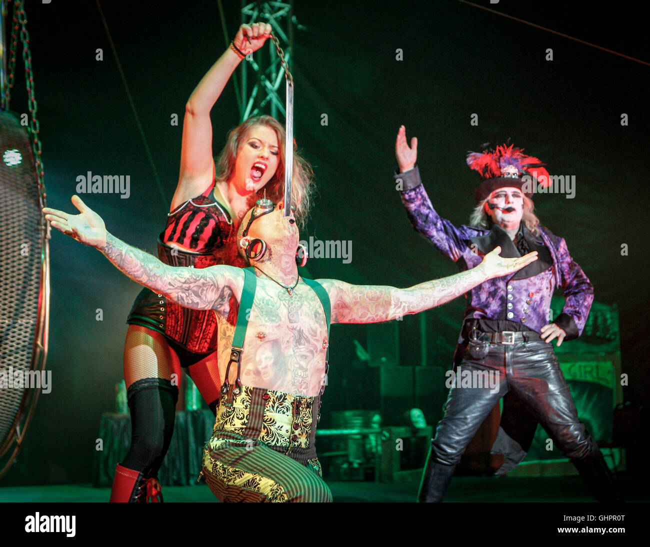 Circus degli orrori cast: Sword swallower, assistente e anello principale a metà le prestazioni. Foto Stock