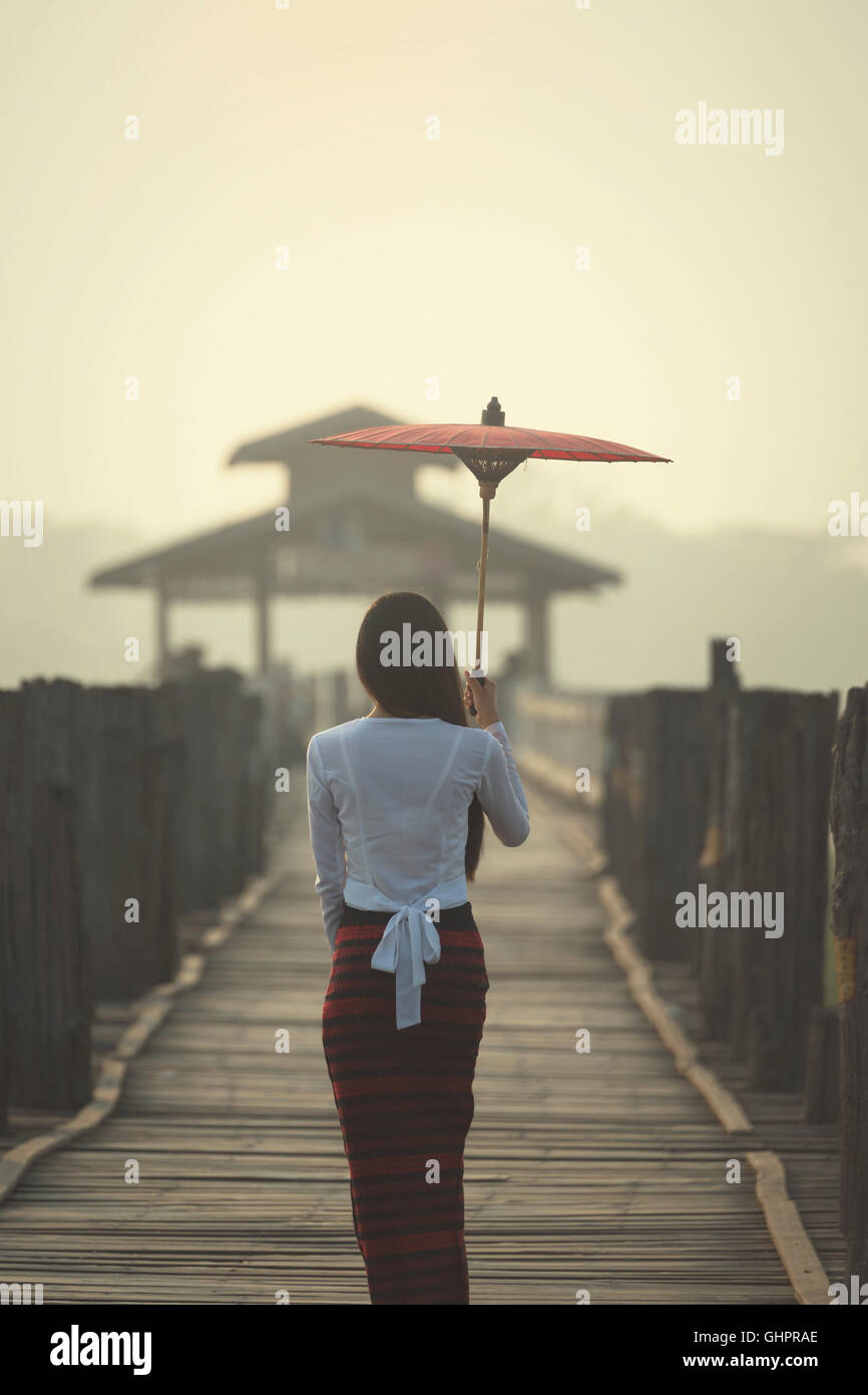 Da sola donna che cammina da sola su U Bein birdge myanmar Foto Stock
