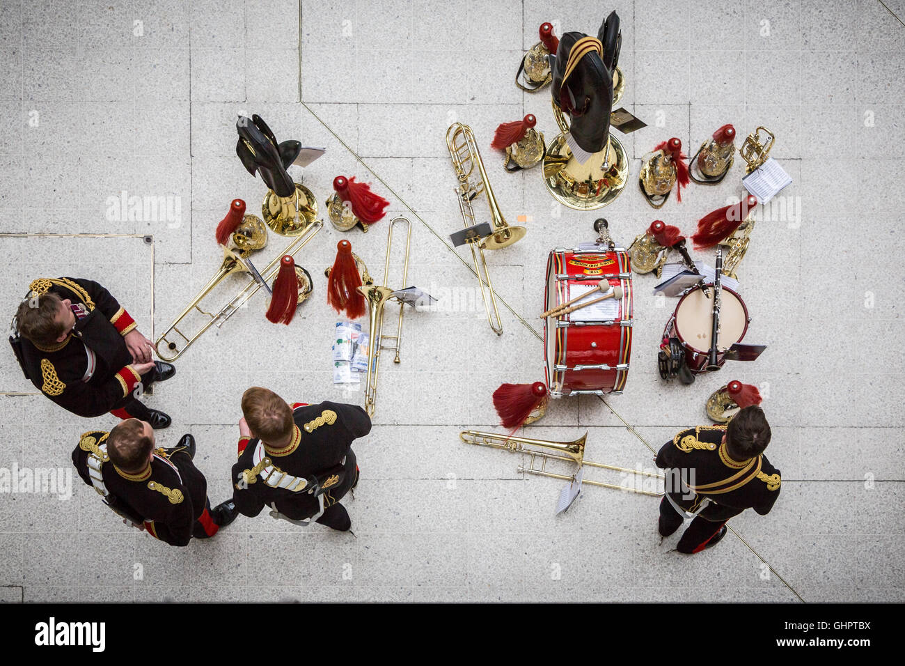 Visto dal di sopra di un militare di brass band lasciare i loro strumenti sul pavimento mentre sono impegnati nella conversazione Foto Stock