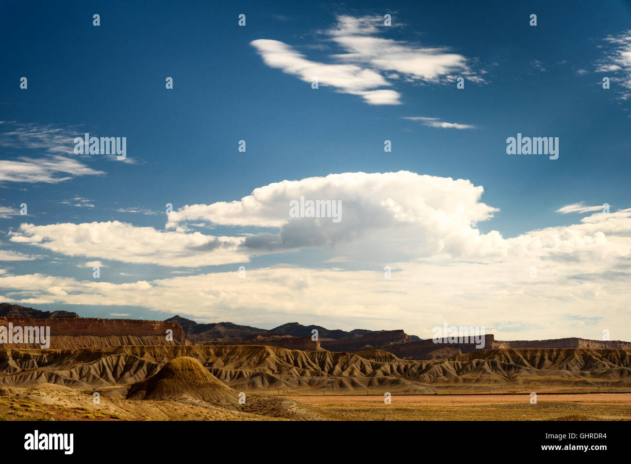 Badlands dello Utah sotto il cielo blu con nuvole bianche. ruvida marrone colline. Foto Stock