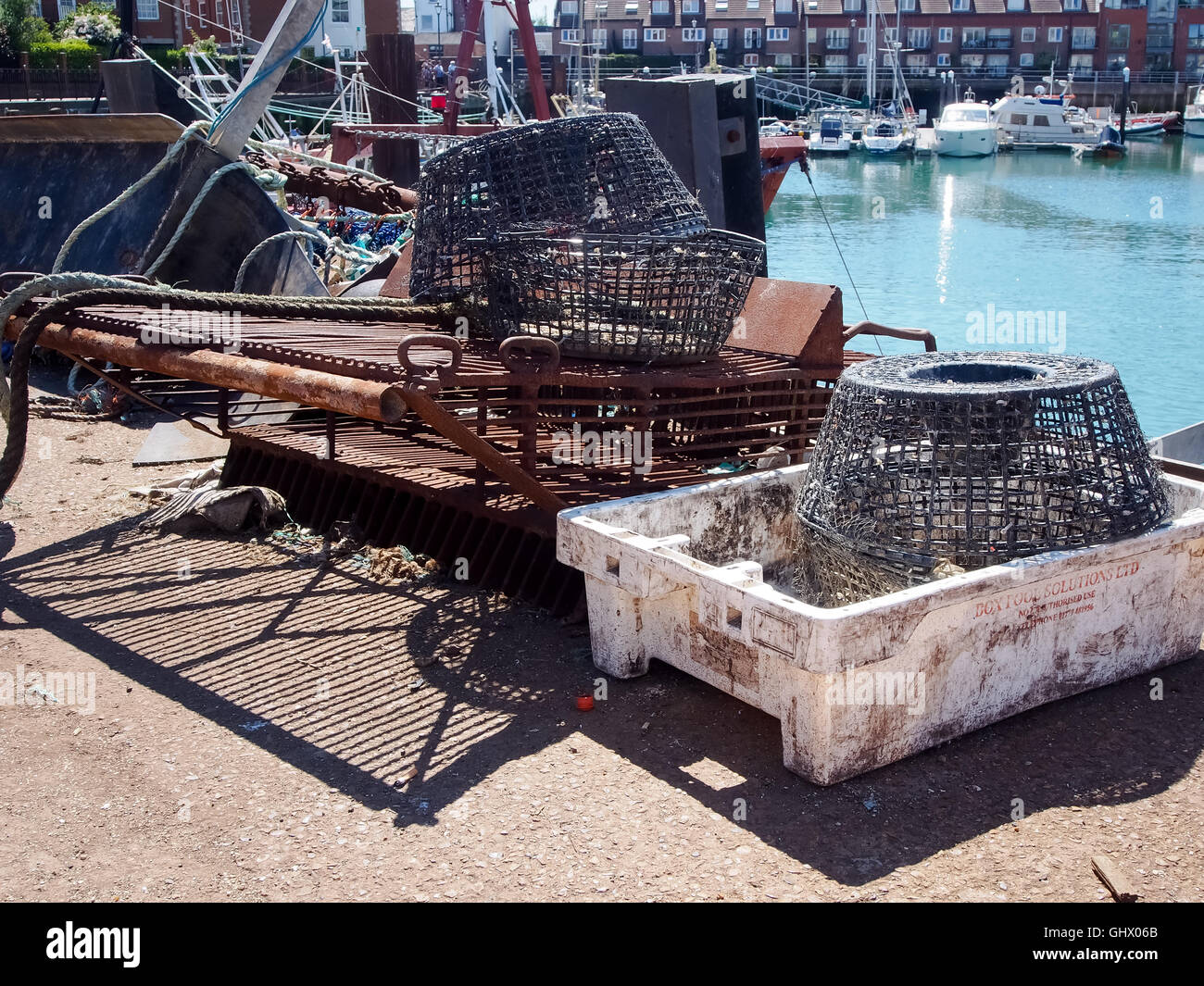Aragosta e granchio lungo pots con il vecchio ingranaggio di pesca a strascico sulla banchina. Foto Stock