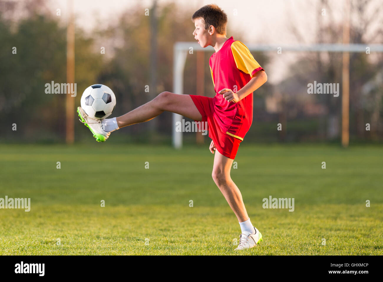 Bambini che giocano a calcio su un campo di calcio Foto Stock