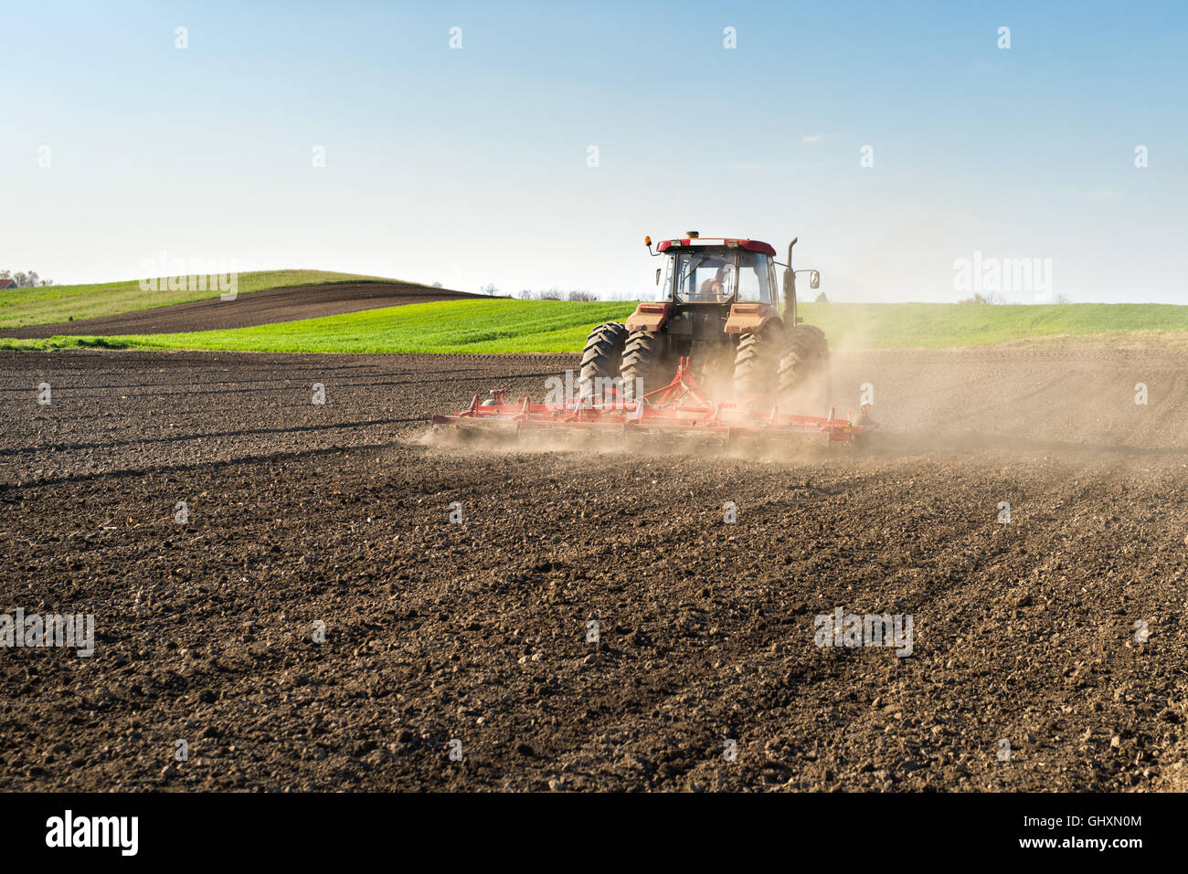 Il trattore preparazione della terra per la semina Foto Stock