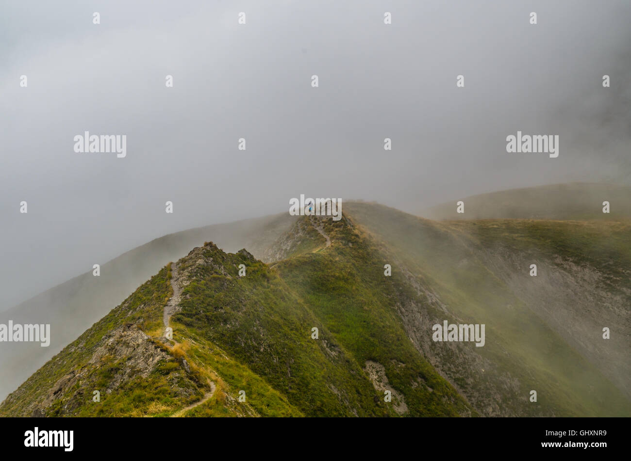Trailrunning femmina nelle nebbiose montagne delle Alpi Lechtal, Tirolo del nord, Austria Foto Stock