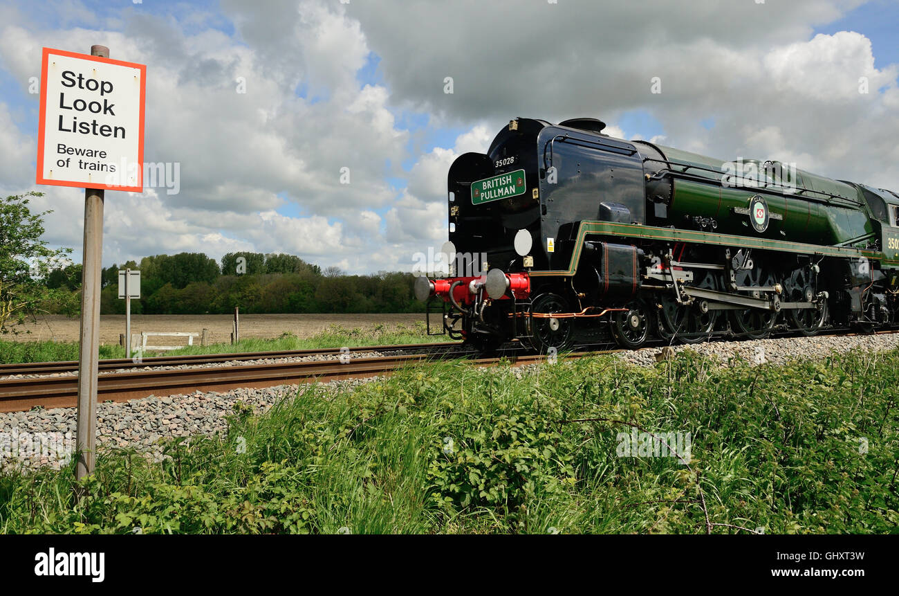 Il Belmond (VSOE) British Pullman in un passaggio pedonale, trainato da Merchant Navy classe locomotiva n. 35028 Clan Line. 14th maggio 2014. Foto Stock