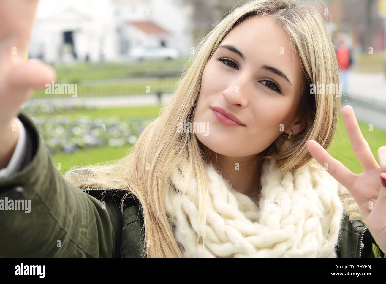 Ritratto di una giovane donna bellissima tenendo selfie. All'esterno. Foto Stock