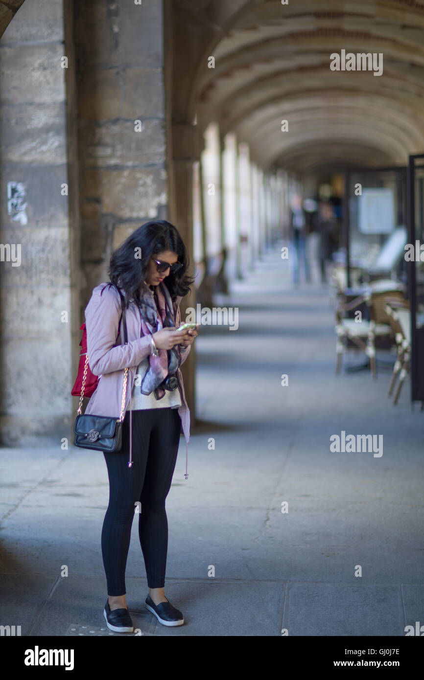 Una donna con il suo telefono, Place des Vosges, Parigi, Francia Foto Stock
