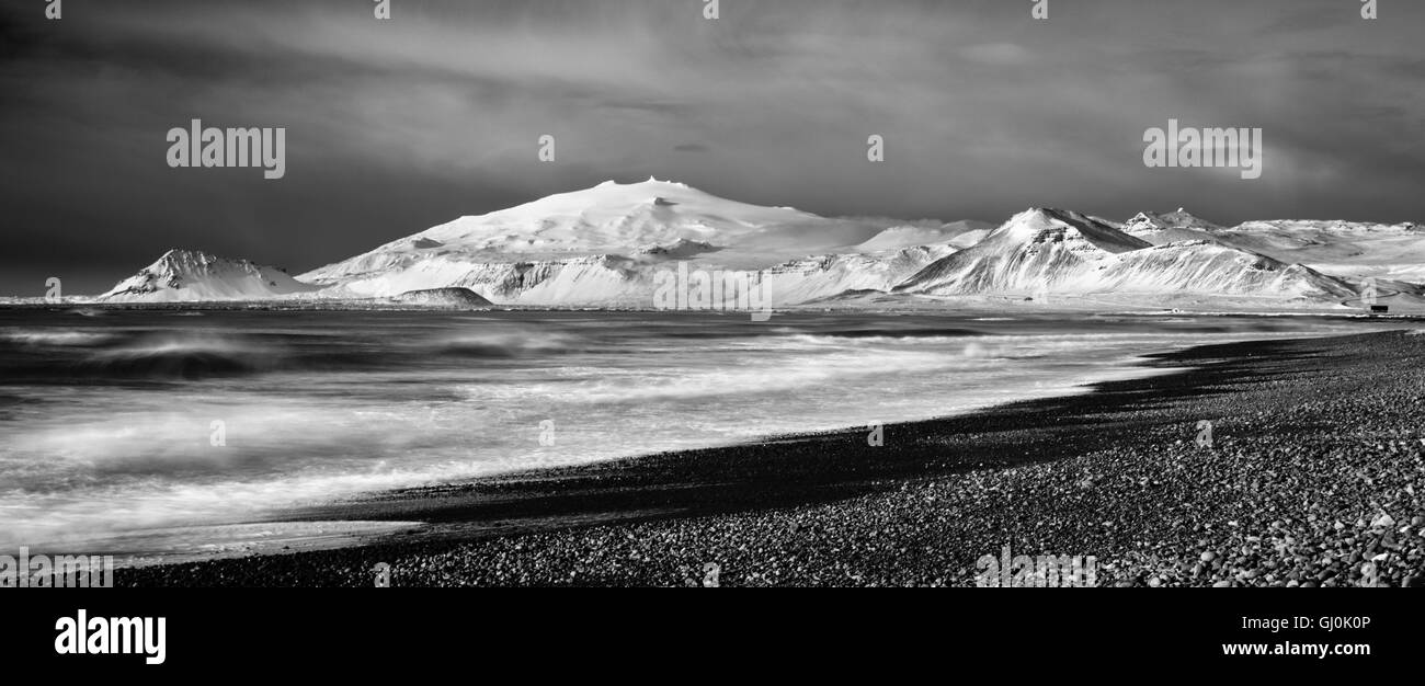Onde che si infrangono a Budavik sotto il Snaefellsjokull, Islanda Foto Stock