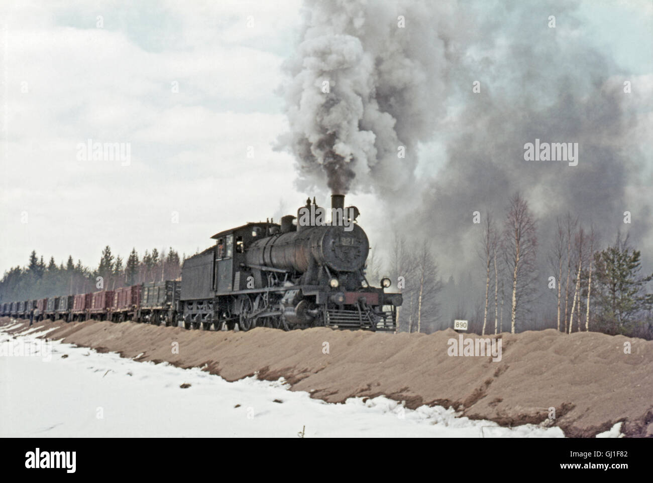 Una stazione ferroviaria finlandese TV1 classe Jumbo 2-8-0 capi una zavorra di sabbia treno attraverso il bosco in prossimità di Kontiomaki, aprile 1972. Foto Stock