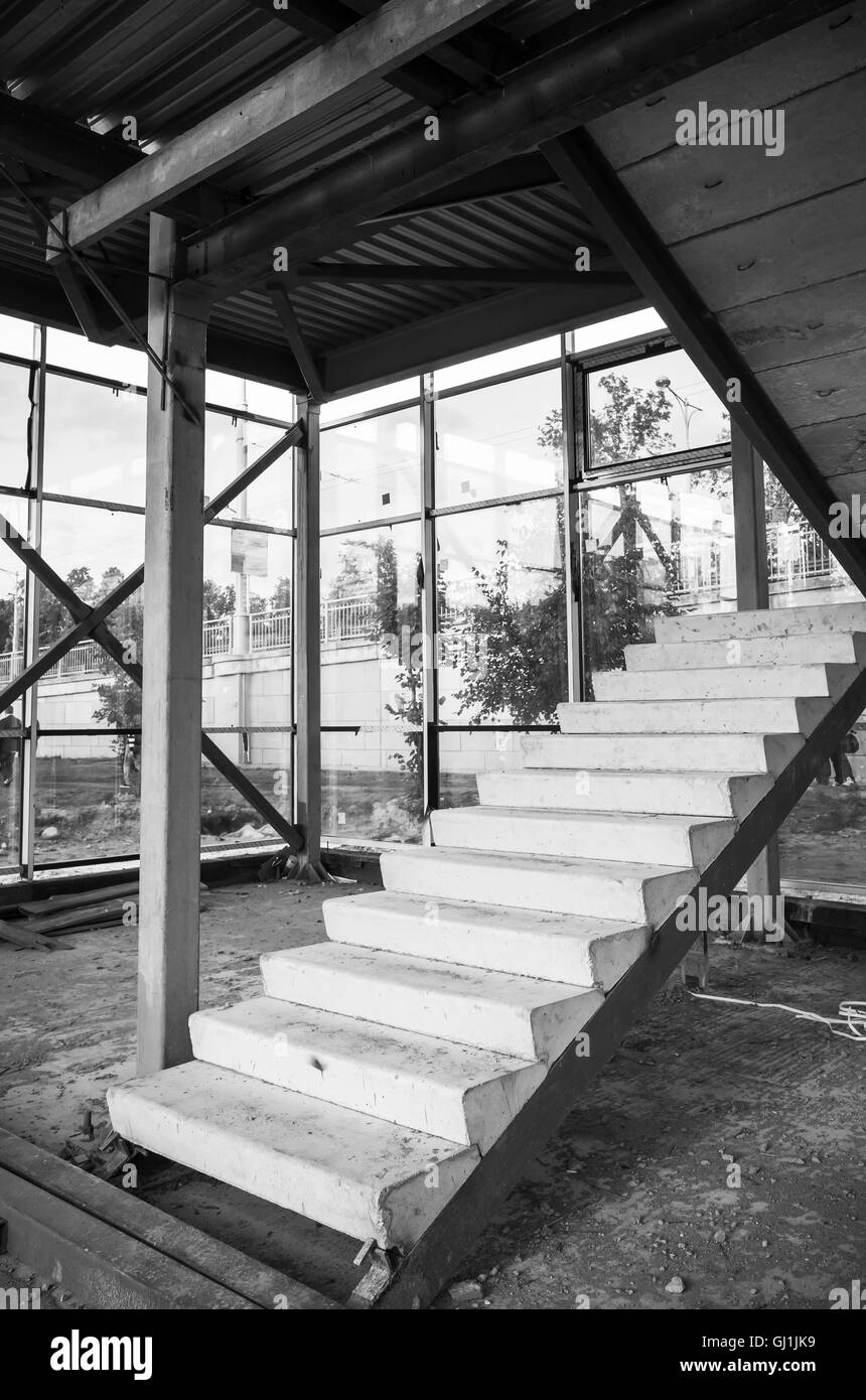 Generico edificio industriale è in costruzione. Frammento interno con incompiuta scalinata in cemento, foto in bianco e nero wi Foto Stock
