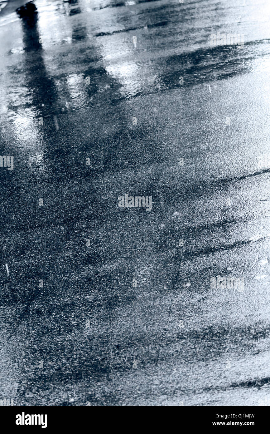 Pavimento bagnato con pozzanghere di acqua e alberi riflessione Foto Stock