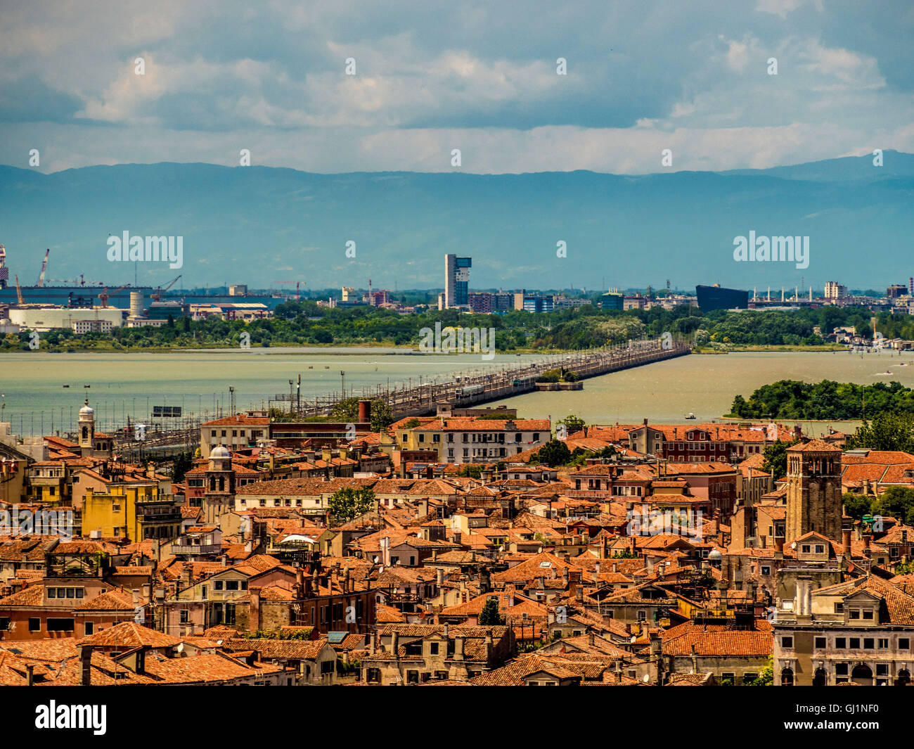 Vista aerea di tetti di terracotta, con la strada e la linea ferroviaria da Italia continentale nella distanza. Venezia, Italia. Foto Stock