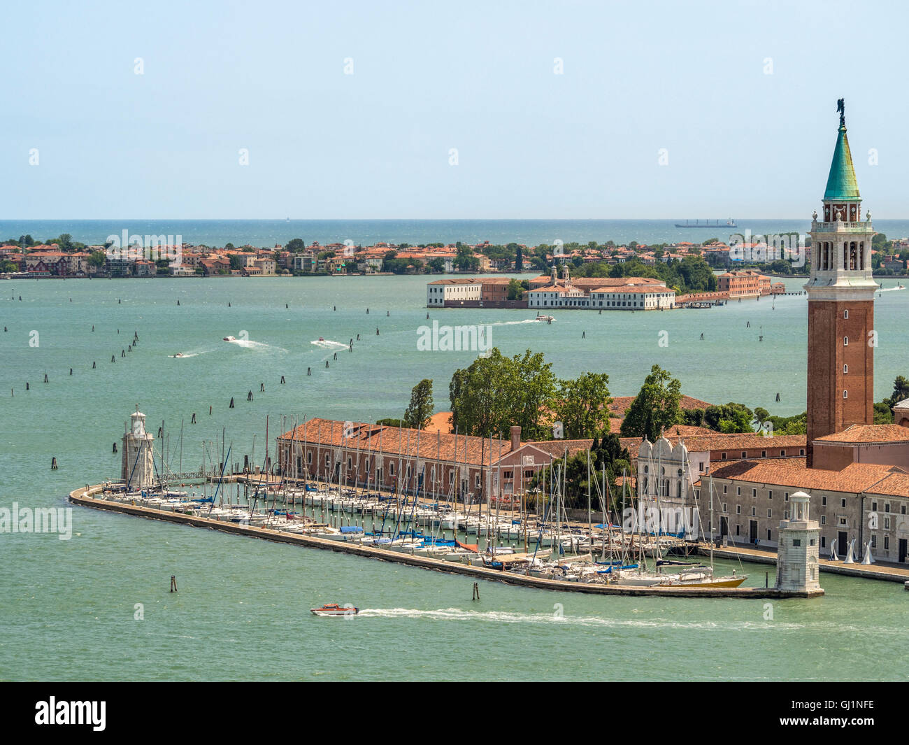 San Giorgio Maggiore porto e la torre campanaria con l'isola di San Servolo, casa di Venice International University dietro. Foto Stock