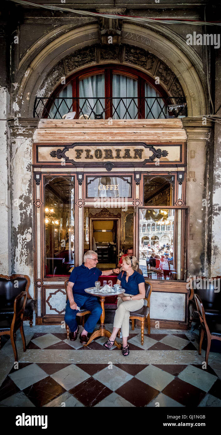 Coppia matura seduto fuori il Caffe Florian avente il caffè. Venezia. L'Italia. Foto Stock