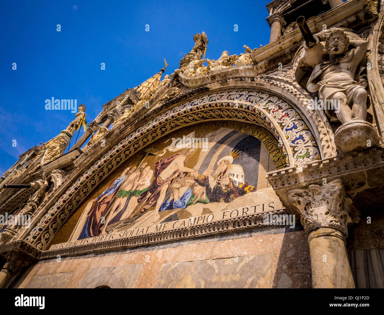 Close up della pietra scolpita il lavoro che circonda la lunetta mosaiced sulla parte esterna del registro superiore del la basilica di San Marco. Foto Stock