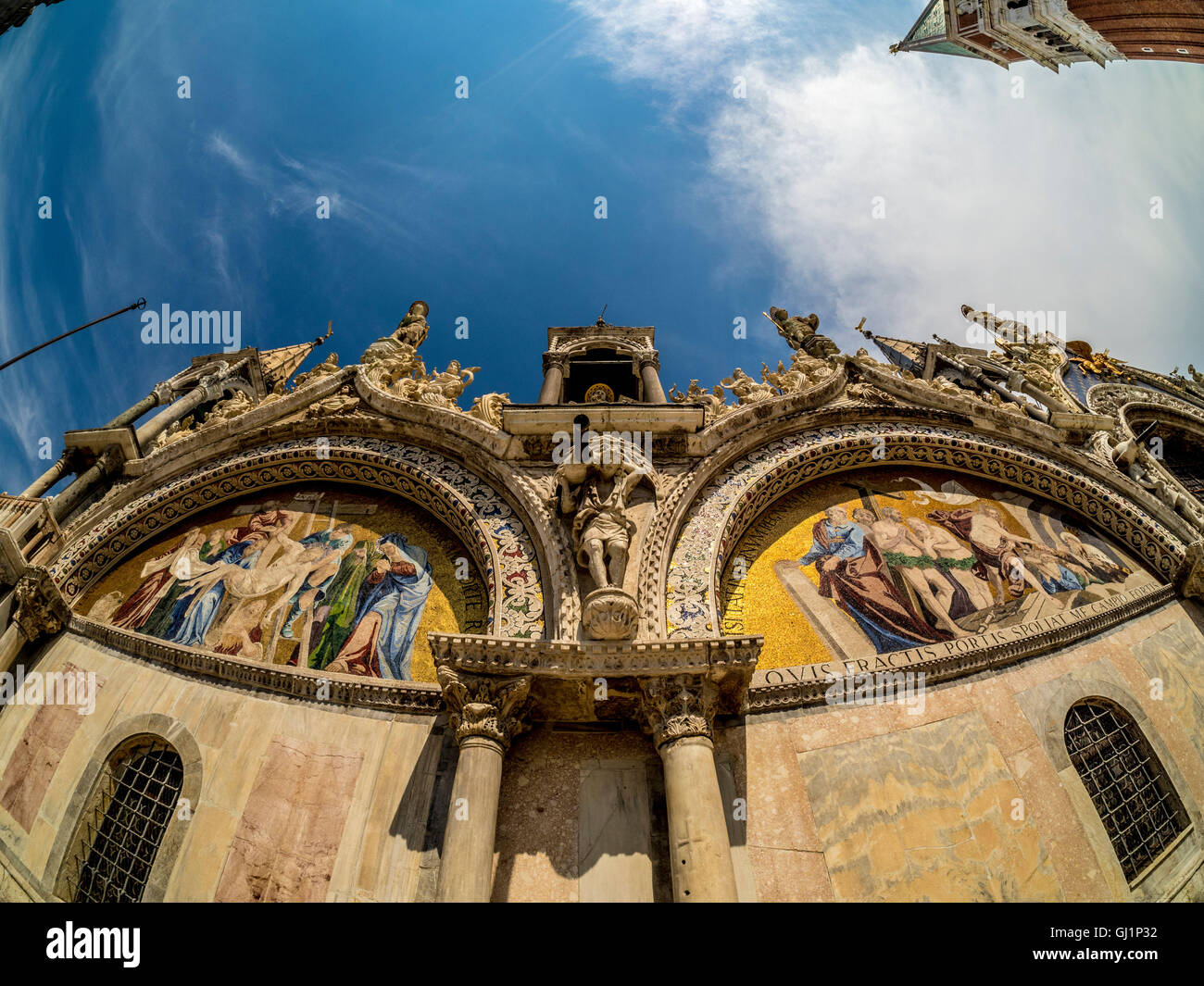 Lente di fisheye di pietra scolpita e lunette Mosaice all'esterno del registro superiore della basilica di San Marco. Venezia Foto Stock