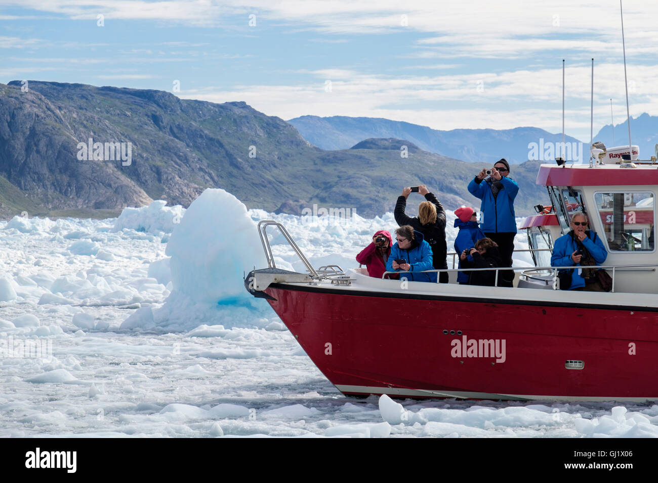 Turisti in gita in barca rossa circondati da ghiaccio marino a Tunulliarfik Fjord fotografando il Qoroq icefjord nell'estate 2016. Narsarsuaq Groenlandia Meridionale Foto Stock