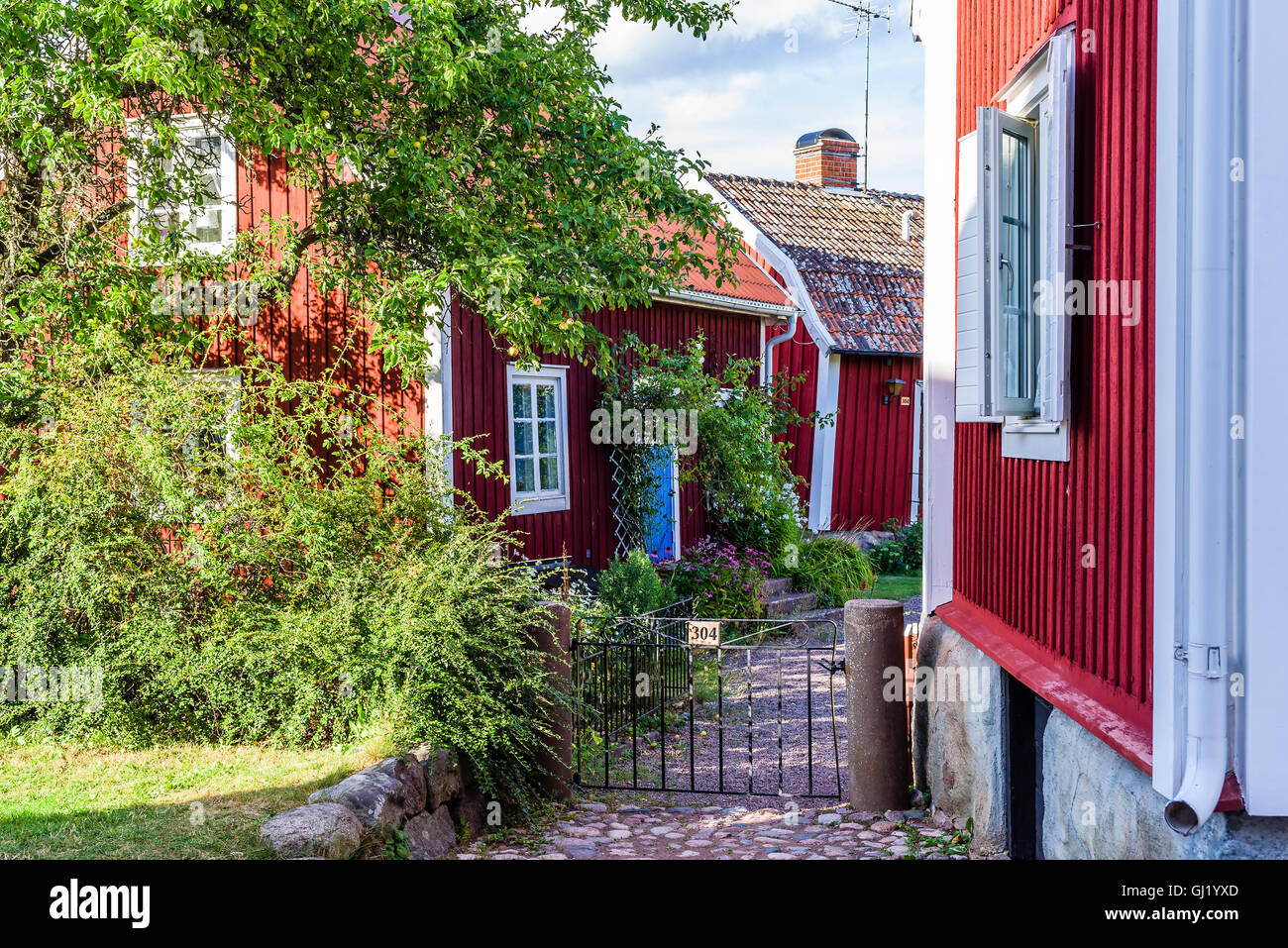 Pataholm, Svezia - Agosto 9, 2016: tipico villaggio home in vecchio stile. Il bianco e il rosso case di legno e piccole porte strette con pa Foto Stock