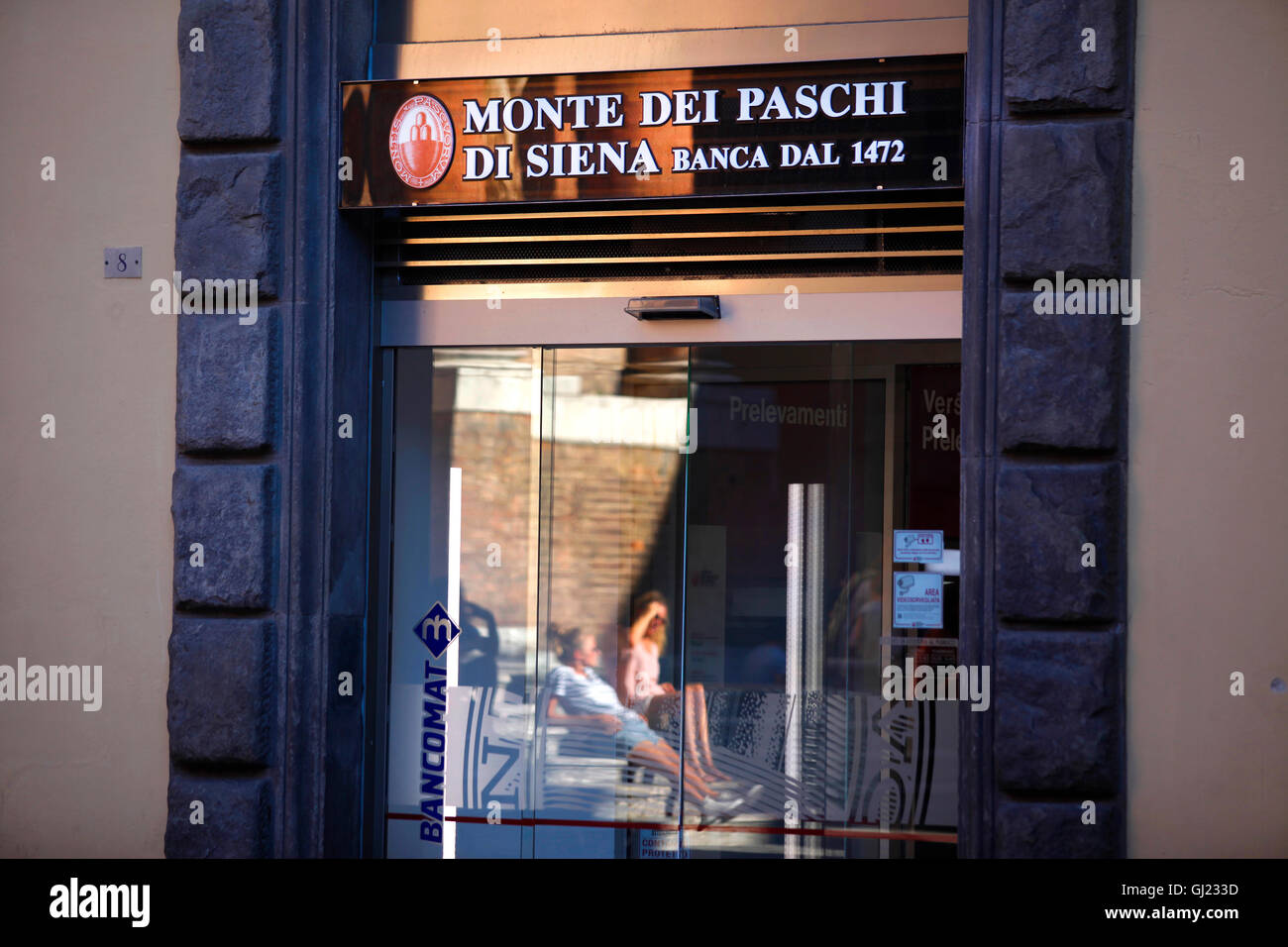 Persone rilassante sulla Piazza Tolomei si riflette in una finestra di una  filiale della Banca Monte dei Paschi di Siena a Siena, Italia Foto stock -  Alamy