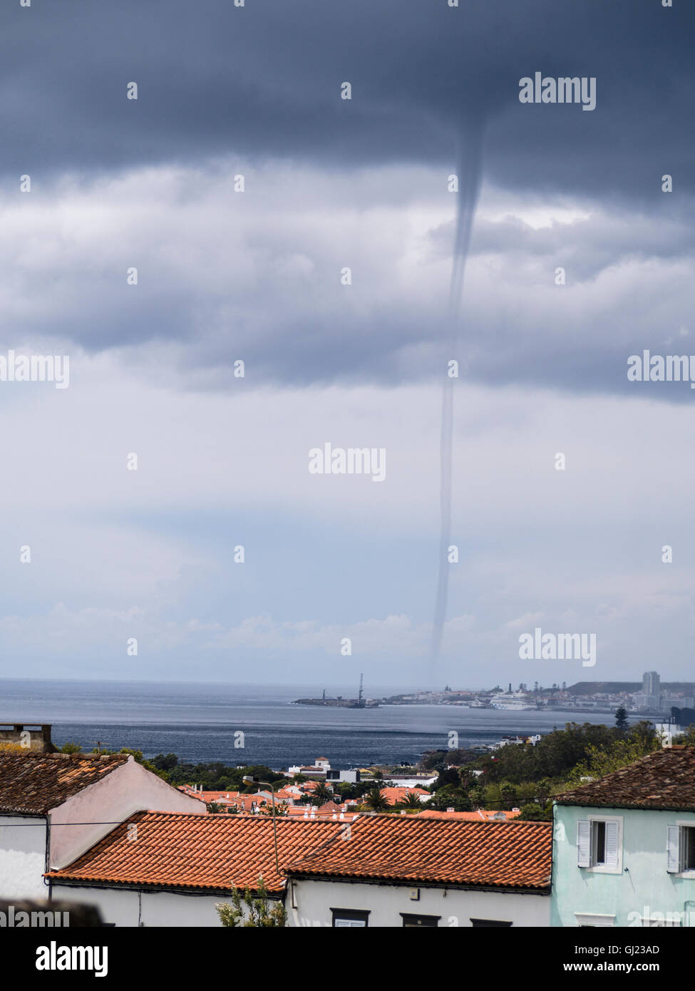 Trombe su Ponta Delgada. Un trombe tornadic appare dal dark nuvole temporalesche nell'oceano appena oltre il centro della città Foto Stock