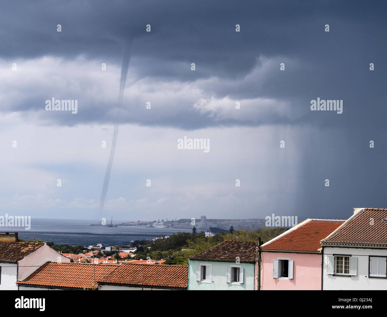 Trombe su Ponta Delgada. Un trombe tornadic appare dal dark nuvole temporalesche nell'oceano appena oltre il centro della città Foto Stock