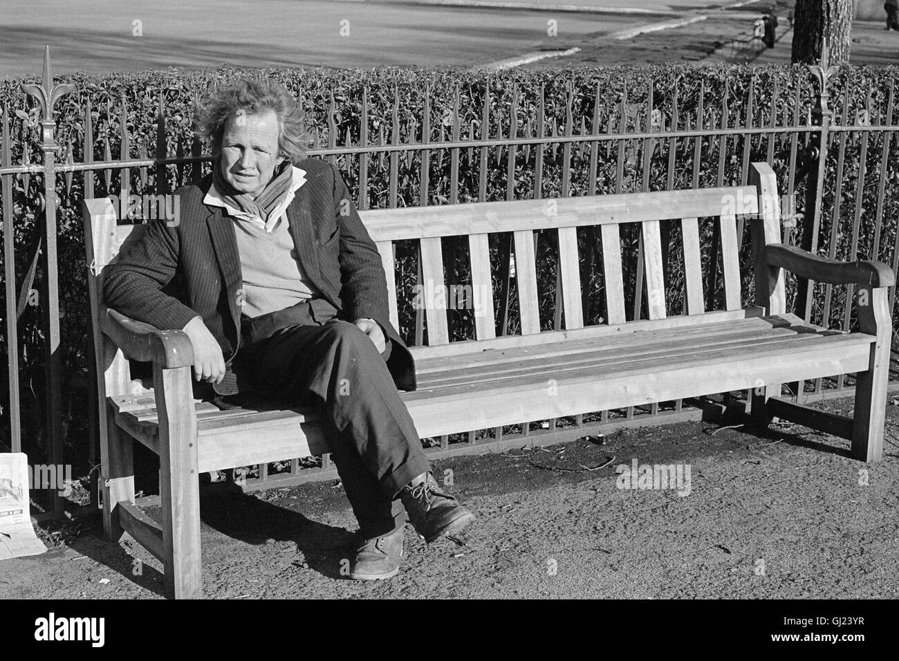Un uomo seduto su una tavola di legno una panchina nel parco nel verde di Glasgow vicino al Palazzo del Popolo nel 1972 Foto Stock