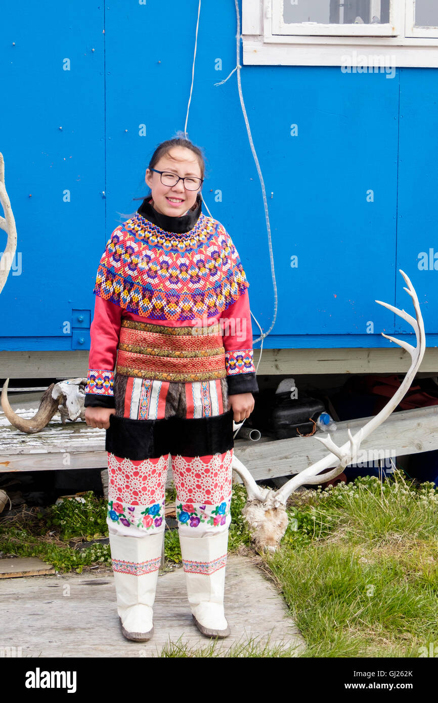 Inuk ragazza indossando colorato costume tradizionale in piedi in posa al di fuori di casa sua. Itilleq, Qeqqata, Groenlandia occidentale. Foto Stock