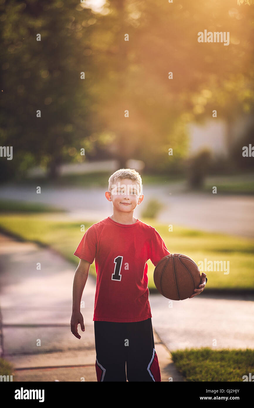 Ritratto di giovane ragazzo tenendo la pallacanestro Foto Stock