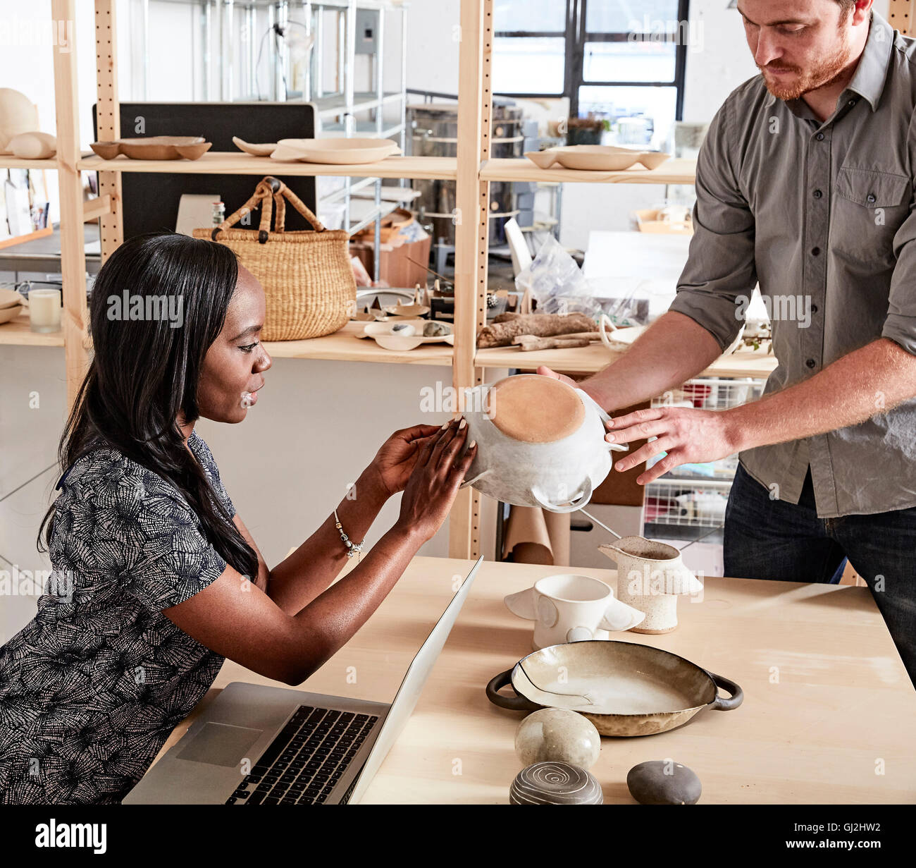 Uomo che mostra collega campioni ceramici Foto Stock