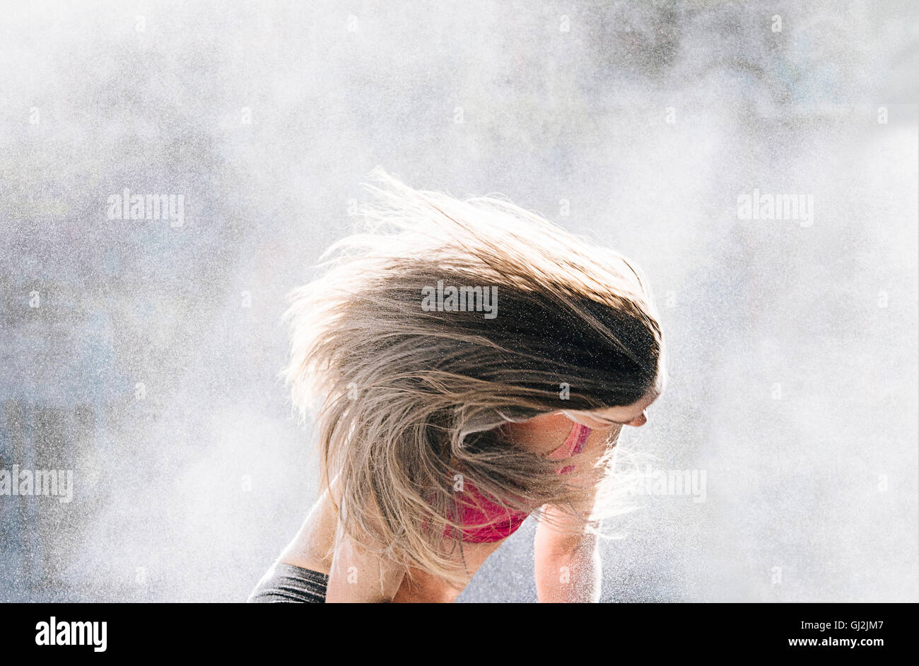 Donna di gettare polvere oggetto capelli indietro Foto Stock