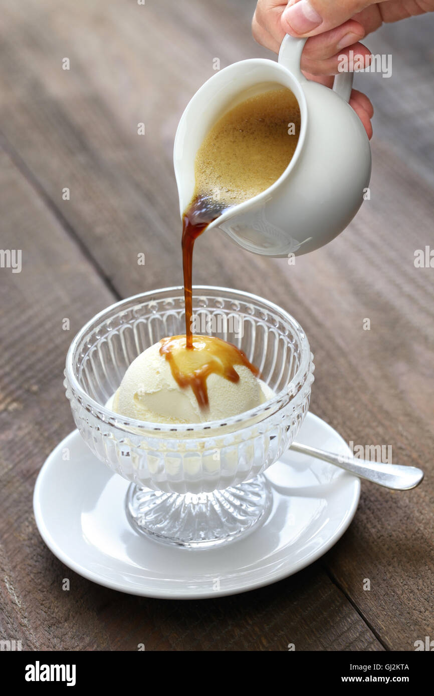 Affogato, versando il caffè espresso al gelato, italiano semplice dessert Foto Stock